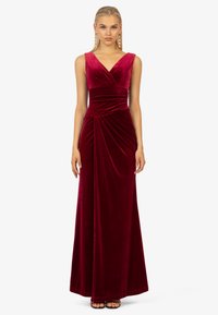 Langes, burgunderfarbenes Samtkleid mit V-Ausschnitt, breiten Trägern, gerafftem Oberteil und drapierten Details im Rock für eine figurbetonte Silhouette.