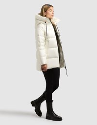 Hvid dunjakke med høj krave, sorte snore og lynlås foran. Båret over sorte leggings og ankelstøvler.