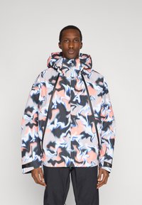 Giacca colorata con motivo a onde e cappuccio; presenta vortici neri, grigi, rosa e bianchi. Chiusura con cerniera e dettagli neri a contrasto.