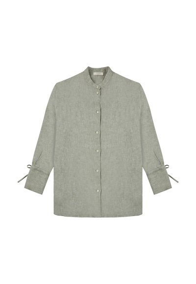 Camicia in lino verde chiaro con colletto, chiusura frontale con bottoni e maniche lunghe con dettagli a fiocco sui polsini. Tessuto liscio e design semplice.