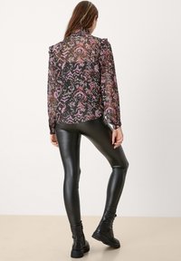 Sheer black blouse with purple and red abstract pattern, ruffled shoulder detailing, paired with black shiny leggings and combat boots.