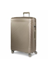 Hard-shell suitcase in metallic beige, featuring a wave-patterned surface, retractable handle, and four dual-wheeled spinner casters.
