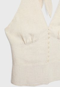 Krämfärgad linnetopp med halterneck, samlade bystdetaljer och en rad av sex framknappar. Tyget har en subtil struktur.