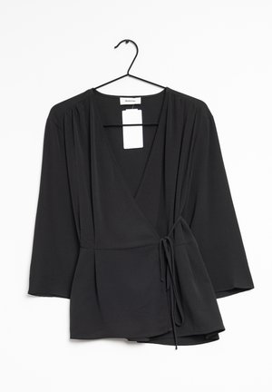 Black long-sleeve wrap blouse with V-neck and side tie, hanging on a black hanger against a white background.