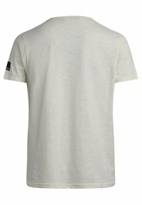 T-shirt à manches courtes en tissu beige clair. Design classique à col rond avec une texture lisse et un logo noir sur la manche gauche.