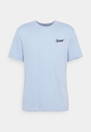 Jasnoniebieska koszulka z krótkim rękawem i okrągłym dekoltem, z małym ciemnoniebieskim logo Nike na lewym piersi na białym tle.