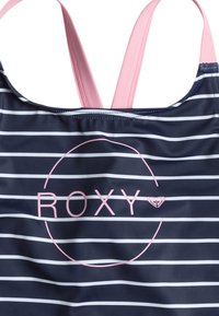 Námornícky modrý plavkový top s pruhmi a ružovými popruhmi a logom. Obsahuje horizontálne biele pruhy a kruhový dizajn okolo názvu značky "ROXY."