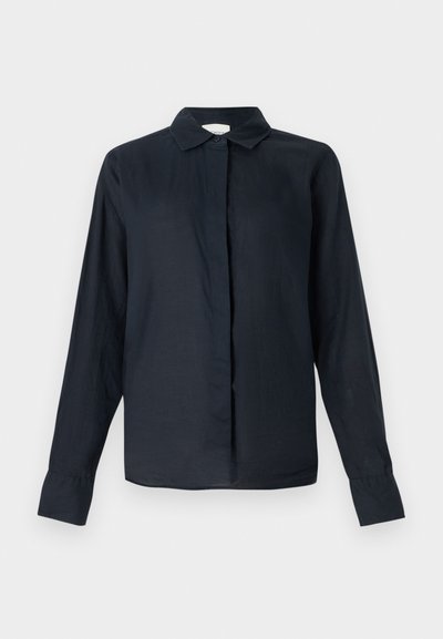 Tumši zils, garām piedurknēm, pogājams krekls ar apkakli, taisnas griezuma, viegla auduma un nedaudz caurspīdīgas tekstūras. Nav redzamu rakstu vai akcentu.