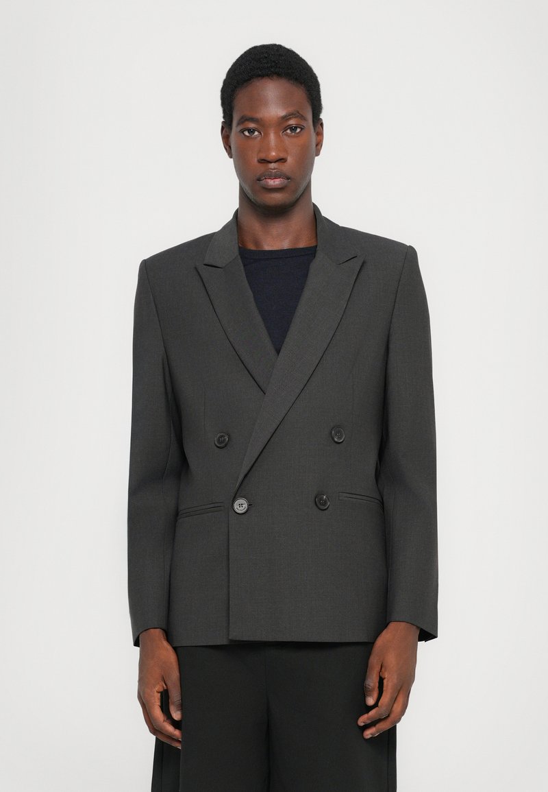 Διπλό γαζί γκρι σακάκι από υφασμάτινη υφή, με κοψ ίματα notch και δύο μπροστινά κουμπιά, με κομψή εφαρμογή.