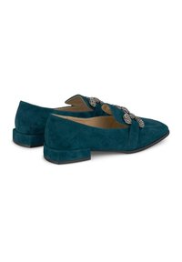 Mocassini in suede color teal con tacco basso a blocco, dotati di un accento decorativo in strass sulla parte anteriore e un design con punta appuntita.