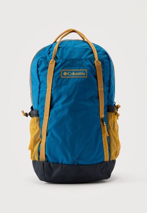 Mochila Columbia azul y amarilla con asas superiores, cremallera frontal, bolsillos laterales de malla y sección inferior negra.