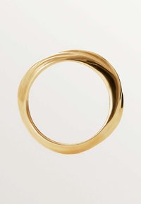 Anillo de oro con una forma suave y redondeada y una ligera ondulación en el diseño. El acabado pulido enfatiza su superficie reflectante.