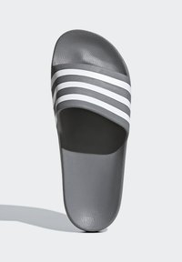 Infradito grigio con una striscia testurizzata che presenta tre righe bianche. La suola è piatta ed è realizzata in un materiale liscio e resistente.