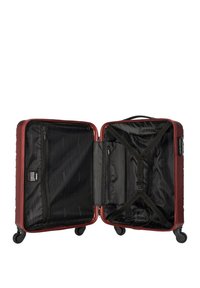 Red hard-shell suitcase with four wheels, zippered compartments, and interior straps. Black textured lining visible inside.
