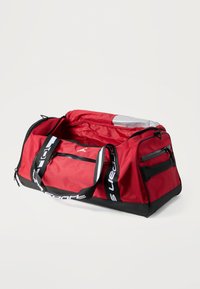 Κόκκινη σακκούλα τύπου duffel με μαύρες λεπτομέρειες, ανθεκτικό ύφασμα, κλείσιμο με φερμουάρ, δίχτυ τσέπης στην κορυφή και ιμάντες με λογότυπο. Χώρος εσωτερικά με χωρητικότητα και πλευρική τσέπη με φερμουάρ.