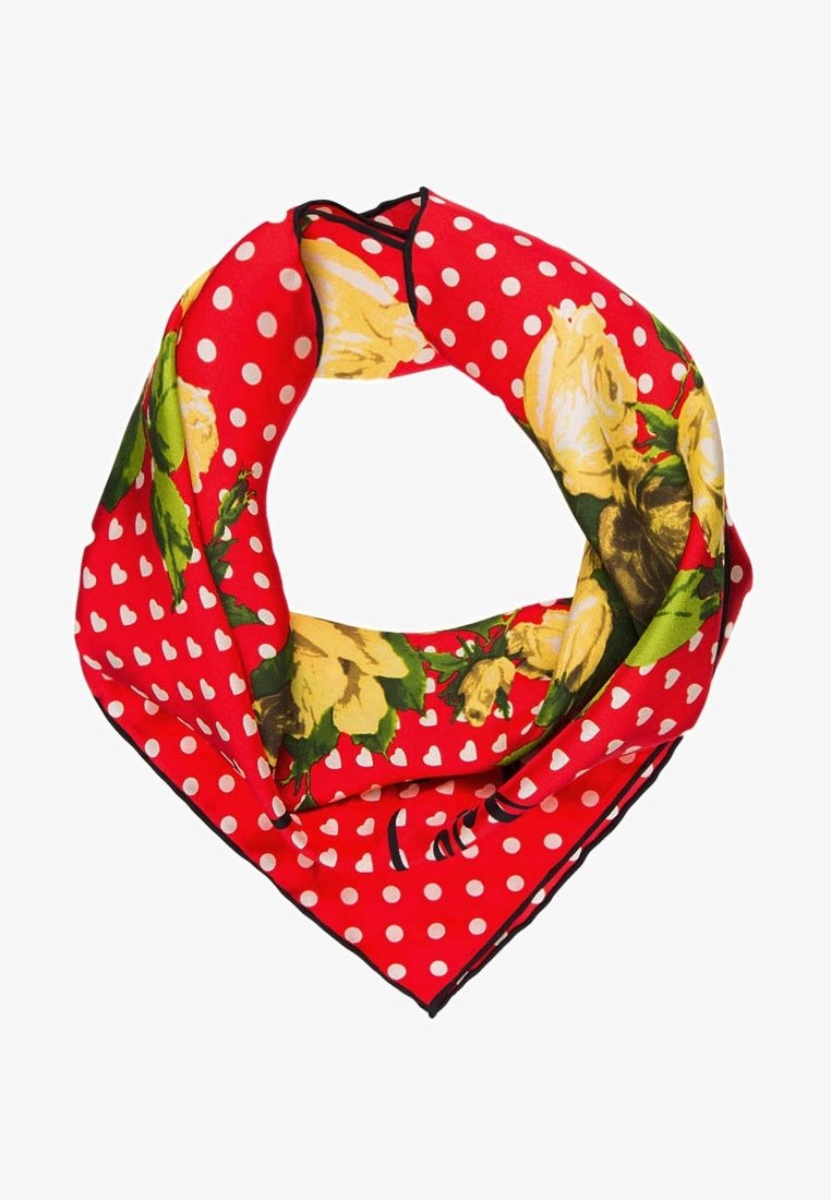 Bandana rouge à pois blancs avec un motif floral de roses jaunes, plié en boucle avec des bords à liseré noir.
