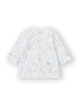 Camiseta blanca de manga larga para bebé con un patrón colorido de casas, árboles y globos; incluye dos bolsillos delanteros y una etiqueta que dice "Mi Dulce Hogar".