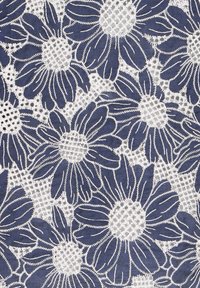 Tissu bleu marine avec motif floral brodé blanc ; présente de grandes marguerites avec des pétales détaillés et un centre texturé, éléments de design contrastants.