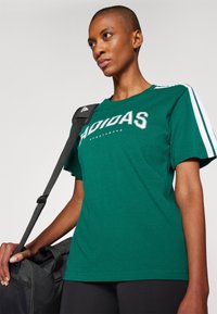 adidas Sportswear LOUNGE SOFT SIDE GRAPHIC - Marškinėliai su spaudiniu - collegiate green