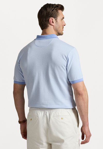 Polo de culoare albastru deschis, cu mânecă scurtă, cu un model texturat, guler contrastant și accente ribbate la mâneci. Croială casual, vedere din spate.
