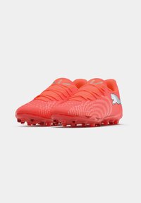 Botas de fútbol de color rojo brillante con diseño texturizado, que cuentan con seis tacos en la suela y un logo plateado en el lateral. Cordones integrados en la parte superior.