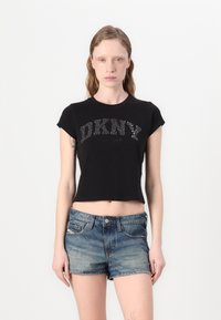 Černé zkrácené tričko s krátkým rukávem, které na sobě má třpytivé logo "DKNY NEW YORK". Slučuje se s světle modrými džínovými šortkami.