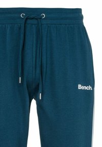 Türkise Jogginghosen mit elastischem Bund, Kordelzug und metallischen Spitzen. Mit weißem "Bench."-Logo am Unterschenkel. Weiche Stofftextur.