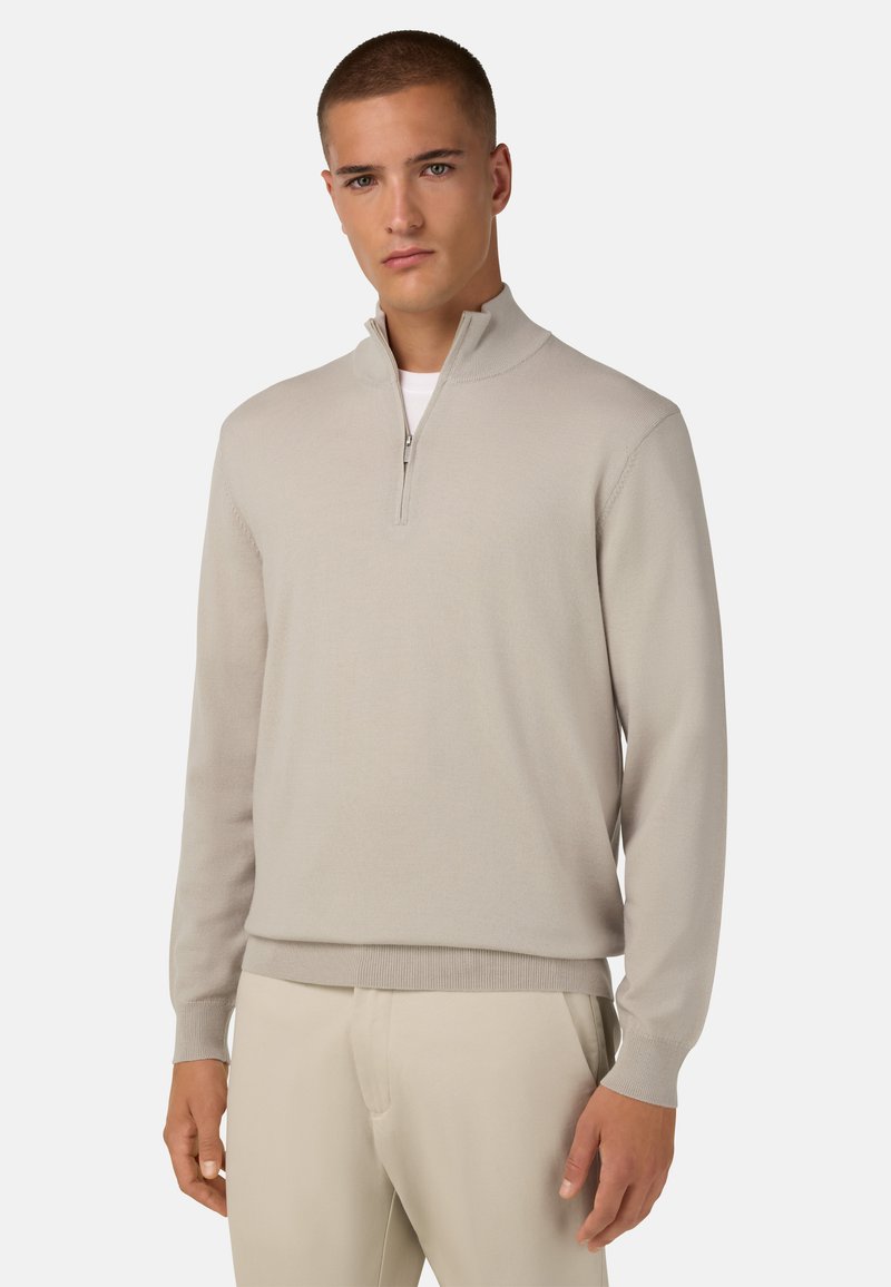 Šviesiai smėlinis megztinis su ketvirčio užtrauktuku ir raukšlėtomis rankogaliais. Pagamintas iš lygaus audinio, pasižymintis prigludusia siluetu ir minimalizmu.