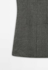 Gilet en lin gris avec une silhouette ajustée. Caractéristiques : coutures verticales, texture lisse, sans matériel ou motifs visibles.