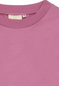 T-shirt viola a maniche corte realizzata in cotone morbido, con scollatura rotonda e un'etichetta con la taglia 38 all'interno del colletto.