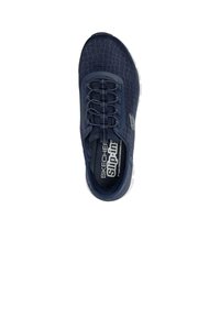 Zapatilla náutica azul marino de tipo slip-on con parte superior texturizada, cordones elásticos y suela de goma blanca. Presenta un logo en el lateral y una plantilla cómoda y acolchada.