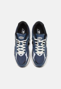 Scarpe da corsa a rete blu con accenti bianchi, logo nero e lacci crema. Presentano una suola ammortizzata e cuciture dettagliate.