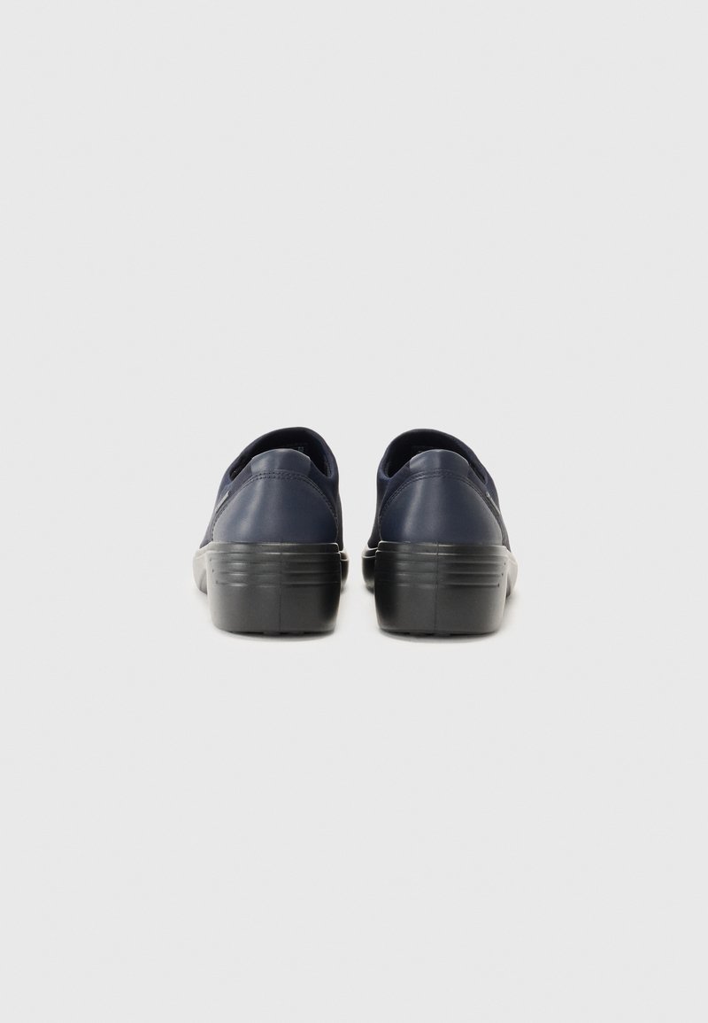 Marinblå slip-on skor med en slät läderöverkänsla och en svart gummisula. Har en modest klack och rundad baksida utan synlig branding.