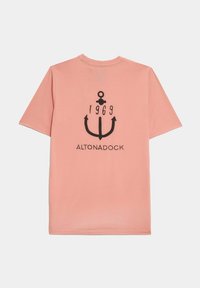 Camiseta de algodón rosa con un gráfico de ancla negra con "1969" arriba y "ALTONADOCK." abajo, cuello redondo y mangas cortas.