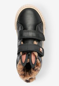 Svarta barnkängor med två kardborreband, fuskpälsfoder och dekorativa kaninöron på tungan mot en vit bakgrund.