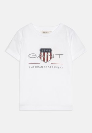 Bijela pamučna majica s kratkim rukavima koja sadrži središnju grafiku s dizajnom štiha, logotipom "GANT" i "1949" u crvenoj, mornarskoj i sivoj boji.