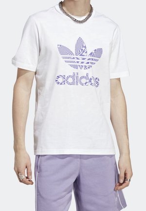 Personne portant un t-shirt Adidas blanc avec un logo violet à motifs et un short violet clair avec des bandes blanches sur les côtés.