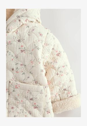 Quiltet jakke i creme med blomster mønstre i pink og grøn. Har hætte og fuzzy manchet detaljer. Inkluderer en frontlomme.