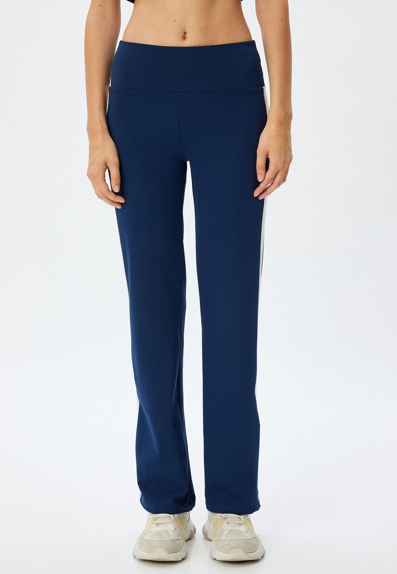Marineblauwe sportbroek met een hoge tailleband, gemaakt van rekbaar materiaal, met zijstrepen en een aansluitend ontwerp bij de benen.