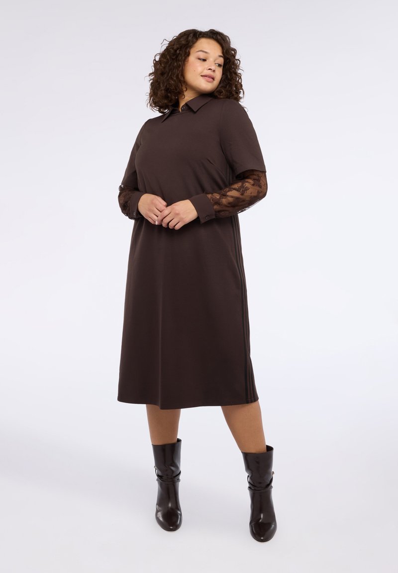 Brązowa sukienka z krótkimi rękawami i koronkowymi wstawkami na ramionach. Posiada kołnierzyk i długość do kolan. W zestawie z czarnymi połyskującymi botkami na kostkę.