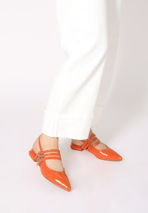 Orange patent leather slingback shoes with a pointed toe, featuring three decorative straps and a low block heel.