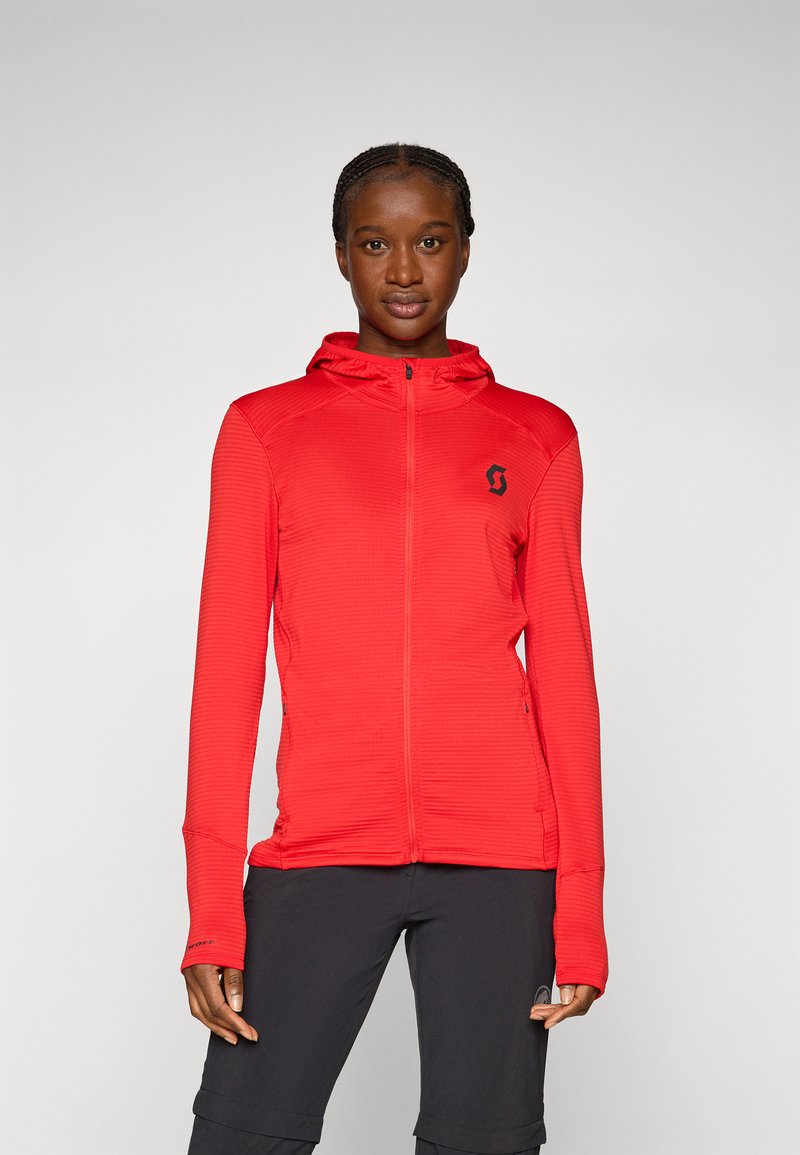 Czerwona bluza z kapturem wykonana z lekkiego, teksturowanego materiału, z pełnym zamkiem błyskawicznym, kieszeniami z przodu i logo na klatce piersiowej, zaprojektowana z myślą o aktywnościach na świeżym powietrzu.