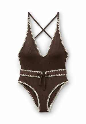 Costume intero marrone testurizzato con bordo bianco smerlato, profonda scollatura a V, spalline incrociate sulla schiena e cintura annodata in vita.