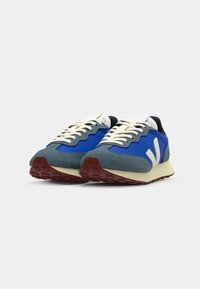 Blå og grå sneakers med mesh- og semsket skinnmateriale, teksturert tunge, off-white snørebånd, gummisåler og markante diagonale hvite detaljer.