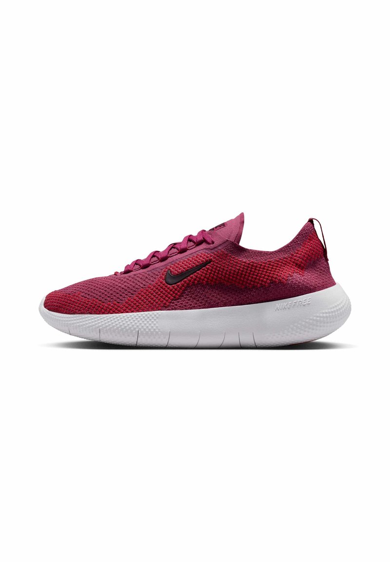 Nike Free kengät punaisella verkkomateriaalilla, mustalla logolla, tekstuurilla, ja valkoisella joustavalla pohjalla, suunniteltu mukavuutta ja hengittävyyttä varten.