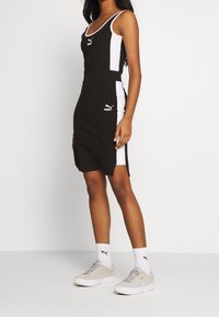 Abito senza maniche bianco e nero con vestibilità sportiva, caratterizzato da un collo foderato, spacchi laterali e dettagli con logo. Abbina con sneakers di colore chiaro.