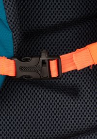 Boucle en plastique noir avec une surface texturée, sangle orange et tissu en maille sombre montrant un design respirant, featuring des petits trous.