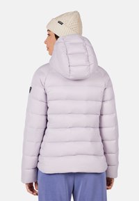 Lys lavendel pufferjakke med vandret quiltning, en aftagelig hætte og et sort logo-patch på venstre ærme. Blødt, isoleret materiale.