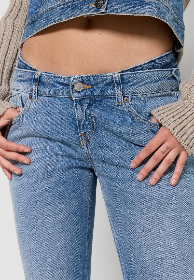 Jeans in denim azzurro chiaro con vita alta, dotati di chiusura con bottone, tasche e leggera scoloritura. Texture a fantasia con dettagli cuciti.