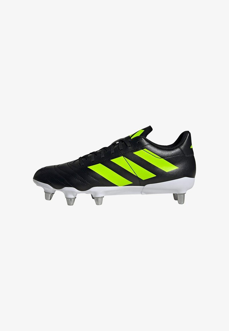 Botín de fútbol negro con rayas verde neón, parte superior de cuero suave, suela blanca y seis tacos metálicos para tracción.